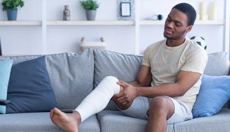 person with a broken leg on couch
