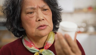 woman looking at pill bottle