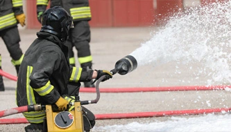 firefighter using foam to put out flames
